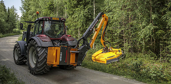 Valtra traktor, der trimmer rabatten med en Kronos Extendo 610 klipperarm